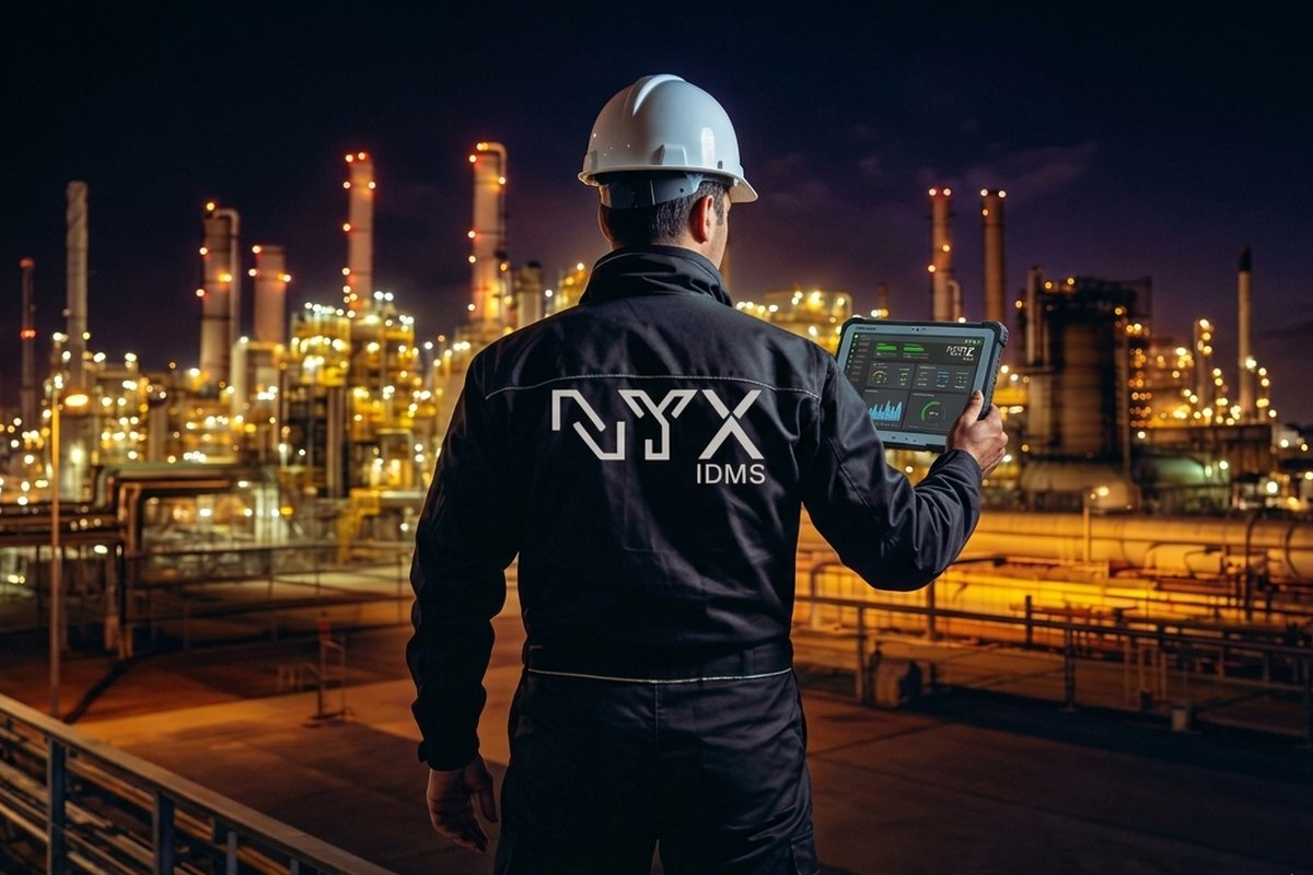 Inspector holding a rugged tablet running the NYX APP at a refinery at night
